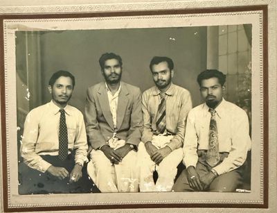 A formal studio portrait of four young men in shirts, ties and a jacket; no caption identifies them or the occasion.