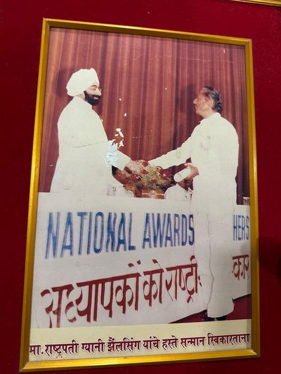 Receiving the honour at the hands of the President of India, Giani Zail Singh — a 'National Award' ceremony for teachers. Framed photograph on a red velvet mount.